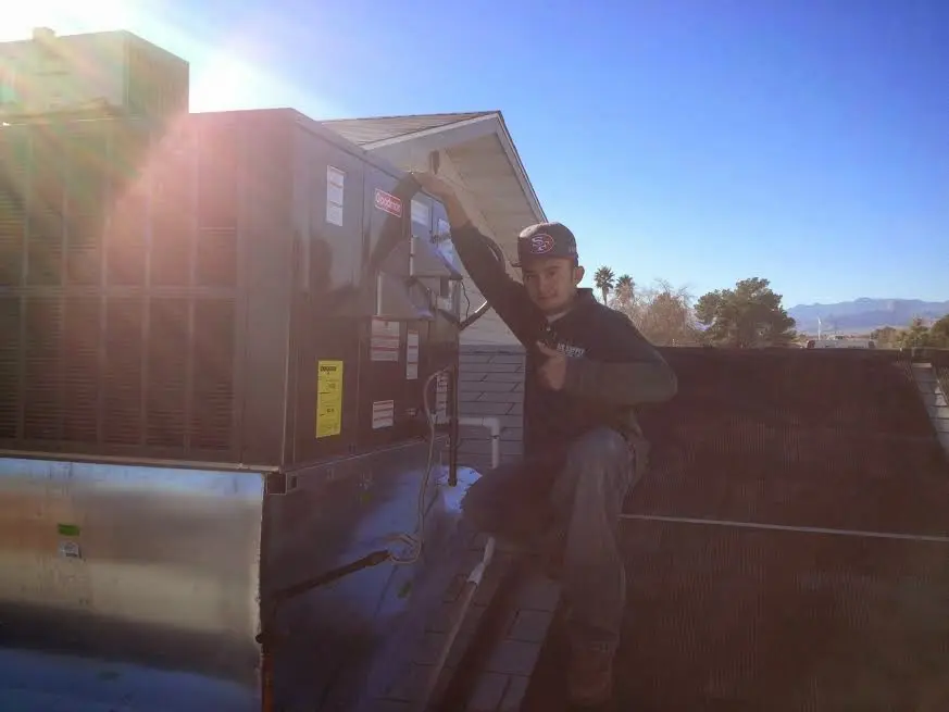 HVAC technician performing Heat Pump Repair on a rooftop unit in Campbellsville